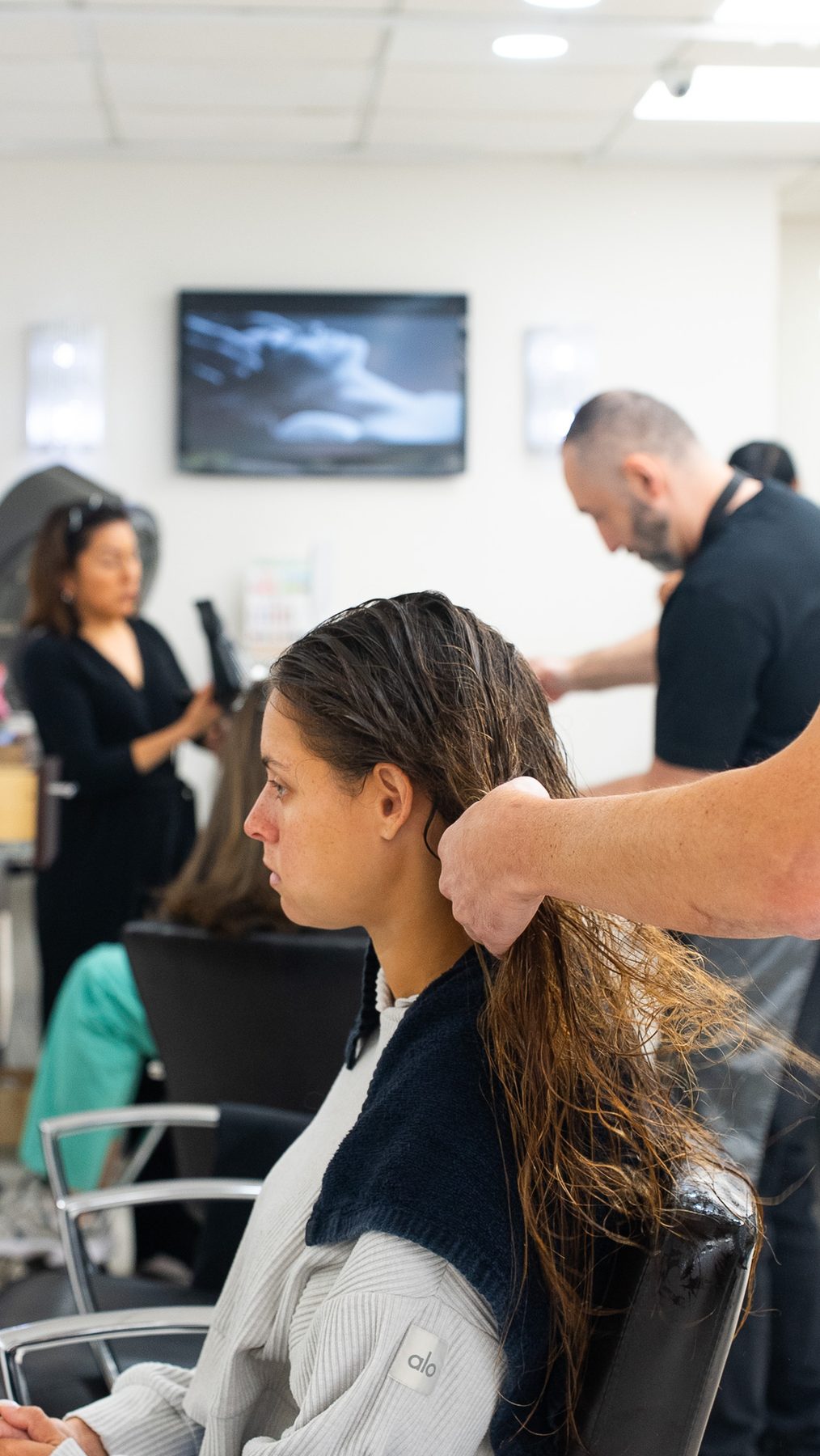 Stylist checking a balayage section by the window at Salon Icon NYC