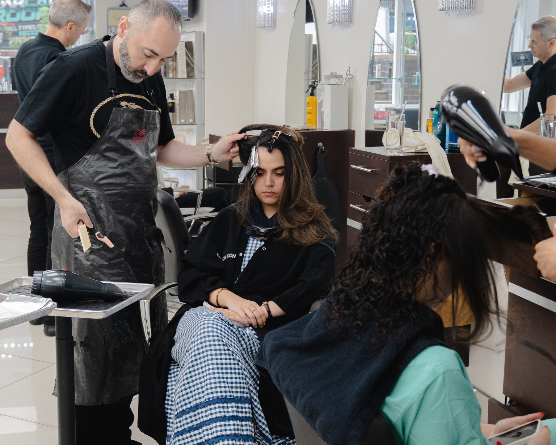 Two stylists blow-drying clients at Salon Icon NYC