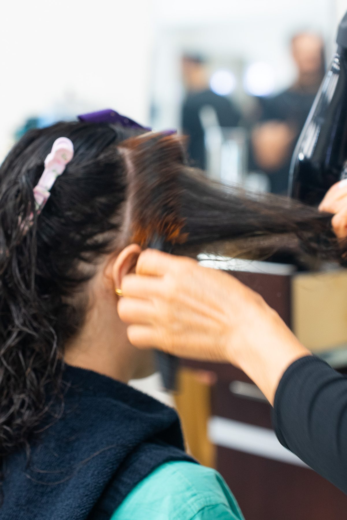 Blow-drying and finishing a client's hair with a round brush at Salon Icon NYC