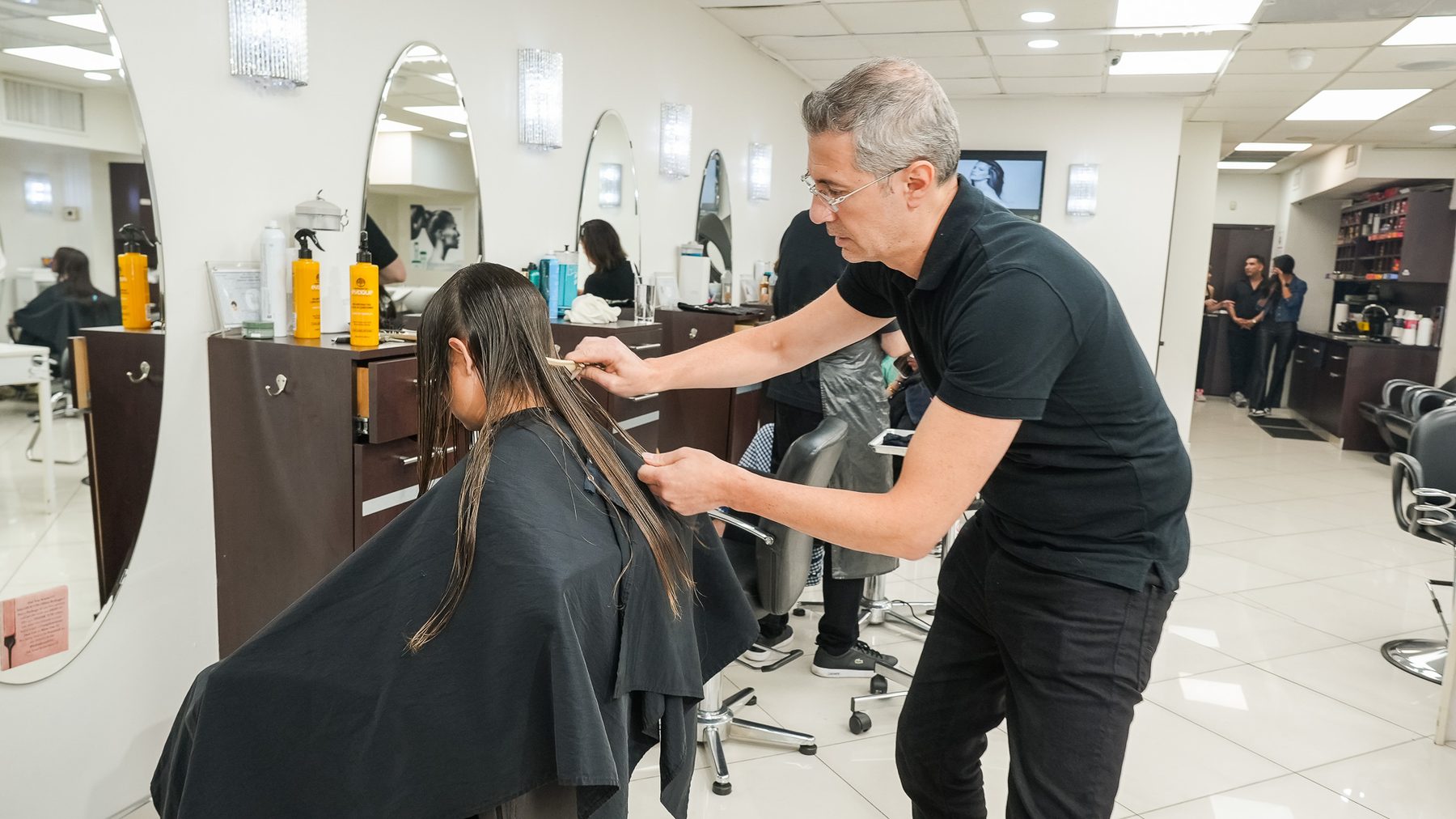 Precision cutting a client's straight hair at Salon Icon NYC