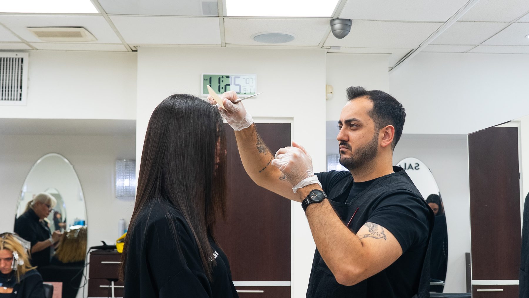 Stylist measuring a precise fringe before cutting at Salon Icon NYC